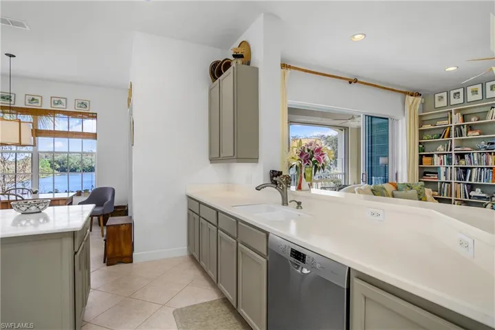 Open kitchen view to family room, lake view from breakfast nook and lanai open doors that "pocket" behind each other on right.