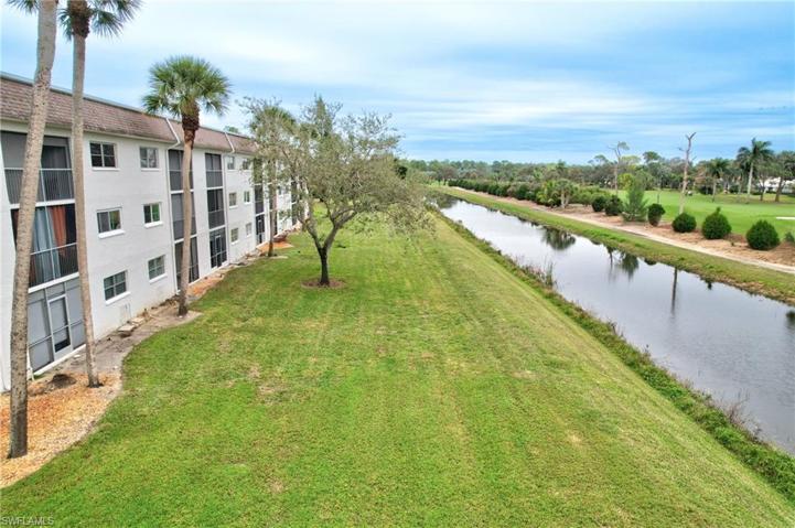 open land behind unit with canal and fairway vies