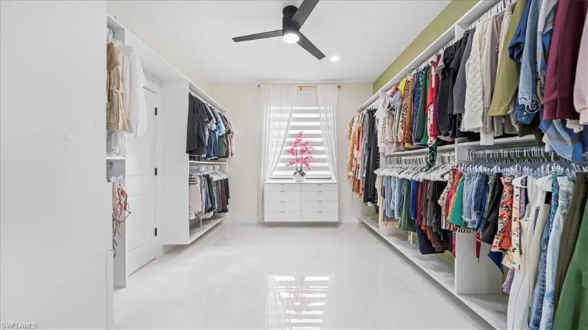Walk in closet with a ceiling fan