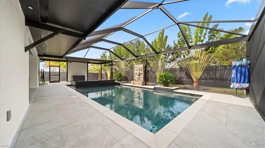 View of pool with a sunroom, glass enclosure, a patio, and a fenced backyard