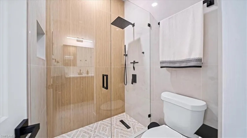 Bathroom with a shower stall and toilet