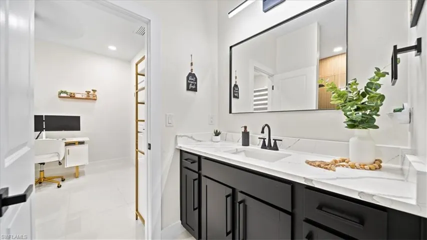 Full bath featuring vanity, light tile patterned floors, and recessed lighting