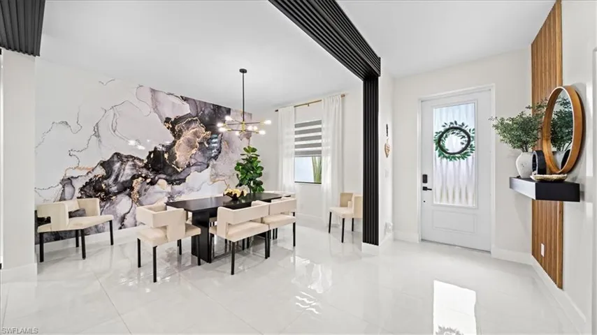 Entryway with an accent wall and a chandelier