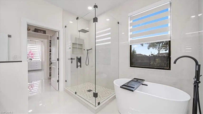 Full bath featuring a soaking tub, a shower stall, and recessed lighting