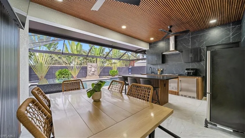 Dining room with a sunroom, light marble finish floors, and recessed lighting