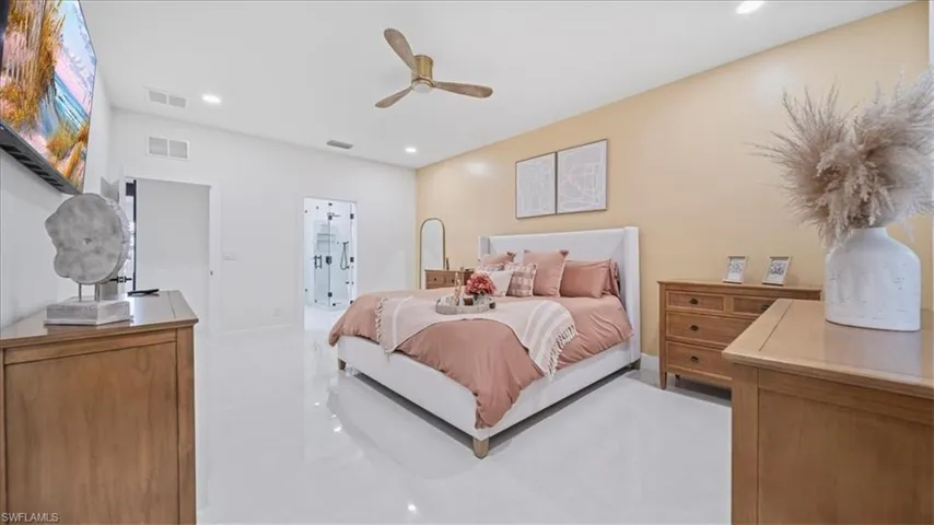 Bedroom featuring ceiling fan, recessed lighting, and ensuite bath