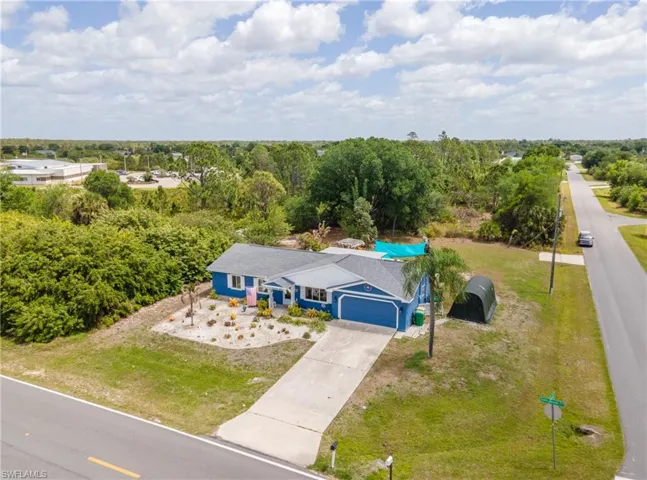Single-story residence featuring a blue exterior and a gray shingle roof