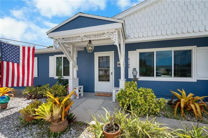 Blue exterior with white trim, featuring a covered entry