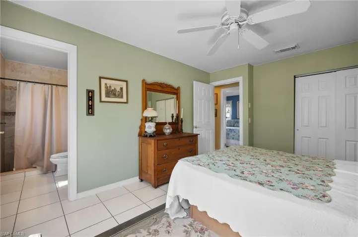 Bedroom featuring light green walls, white trim, and white tile flooring