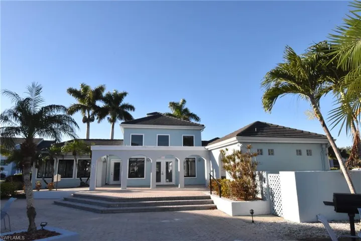 View of front of property with french doors, a patio area, and stucco siding