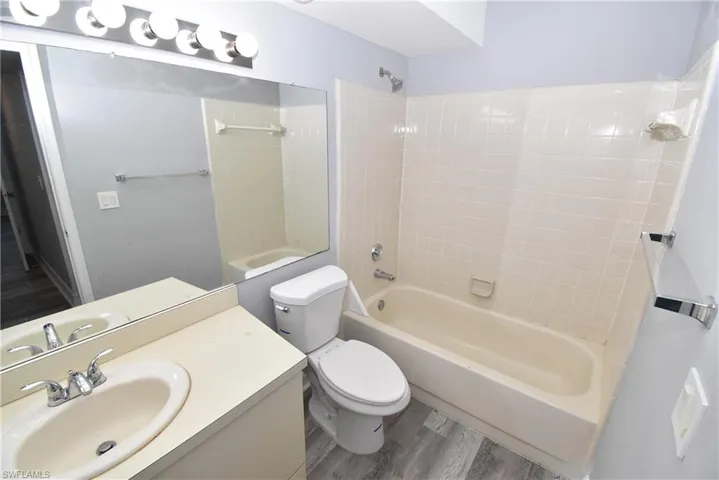 Full bath with vanity,  shower combination, and wood finished floors