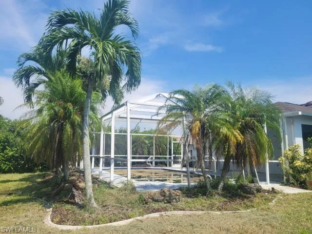 Back of property with a lawn and glass enclosure