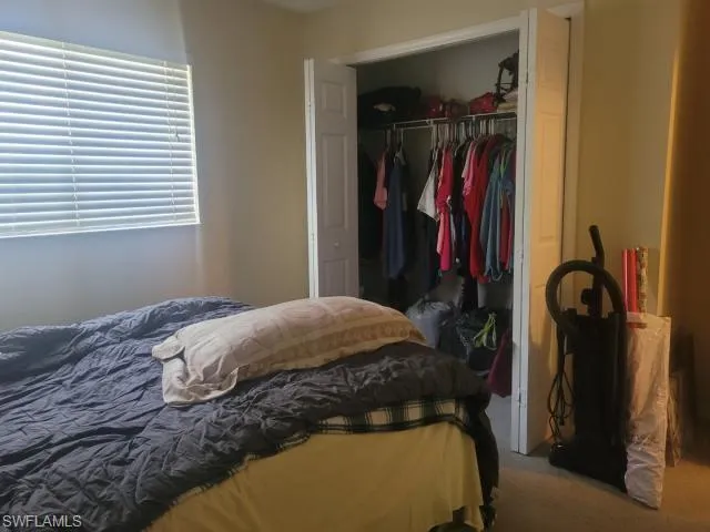 Carpeted bedroom featuring a closet