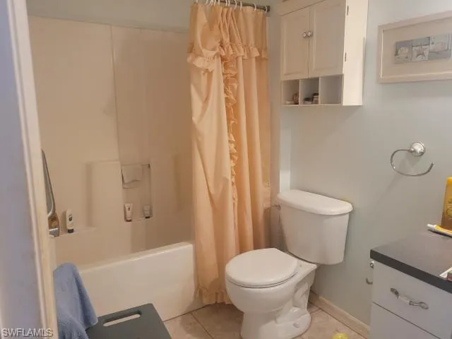 Full bathroom featuring shower / bath combo, toilet, tile patterned flooring, and vanity