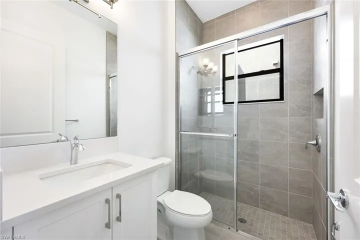Bathroom with vanity, toilet, and a shower with door