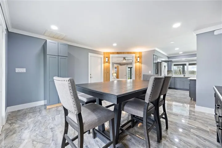 Dining area with crown molding and recessed lighting
