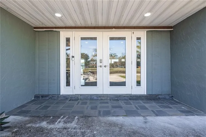 View of exterior entry with french doors, a patio, and stucco siding