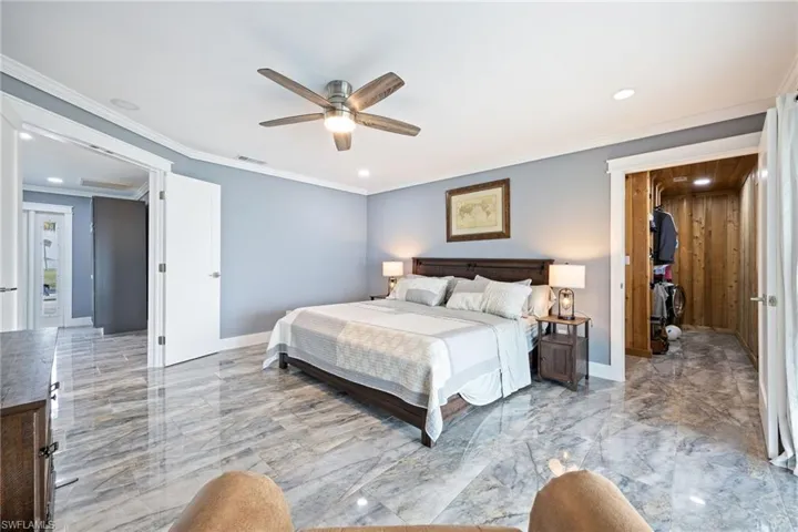 Bedroom with light marble finish flooring, ceiling fan, recessed lighting, and ornamental molding