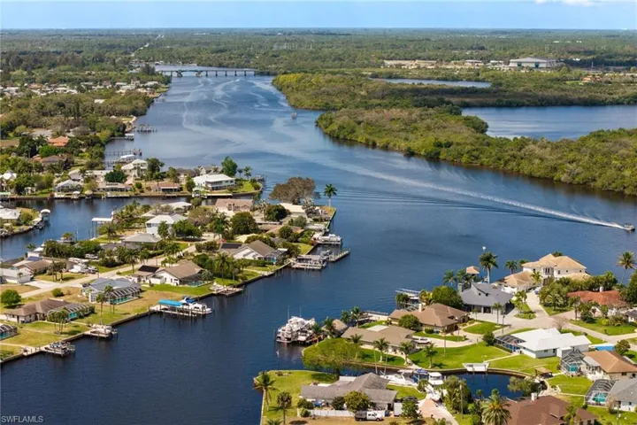 Aerial perspective of suburban area featuring a large body of water and a heavily wooded area