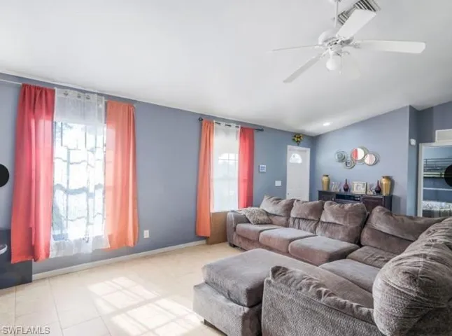 Vaulted ceiling with a white ceiling fan and integrated lighting