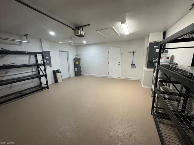 Spacious garage featuring a finished floor, white walls, and multiple lighting fixtures