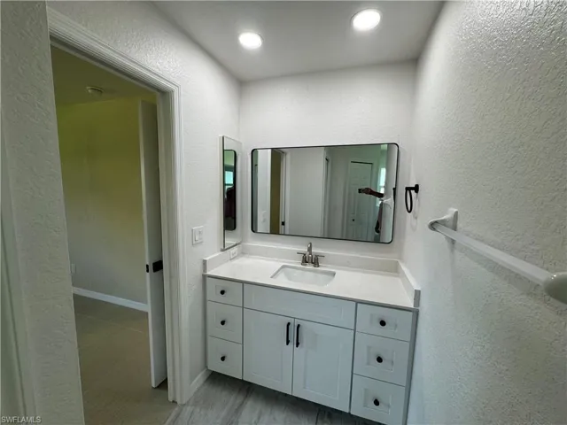 Vanity bathroom featuring a single basin, light-colored countertop, and framed mirror