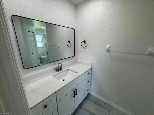 Bathroom vanity featuring a rectangular undermount sink, a silver-finish faucet, and a quartz-finish countertop