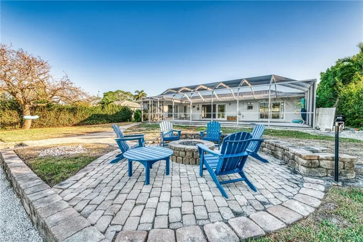View of patio featuring glass enclosure and an outdoor fire pit