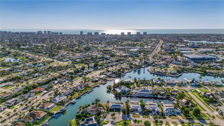 Aerial view of property and surrounding area with a nearby body of water and nearby suburban area