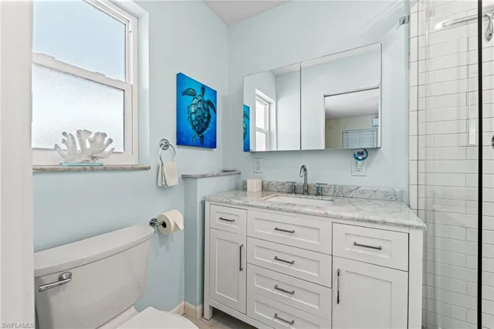 Full bathroom featuring plenty of natural light, vanity, and tiled shower