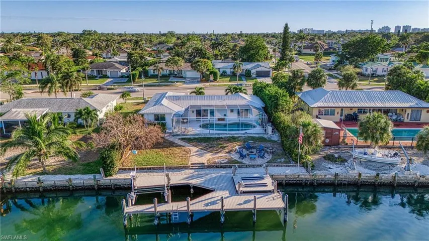 Aerial perspective of suburban area featuring a nearby body of water