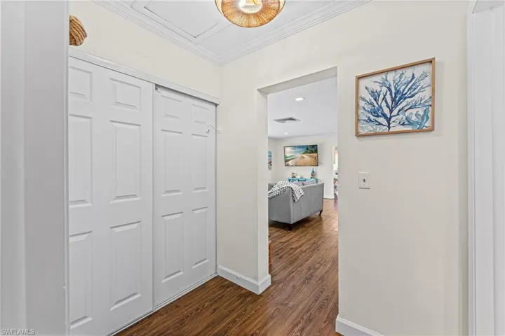 Corridor with crown molding and dark wood-style floors