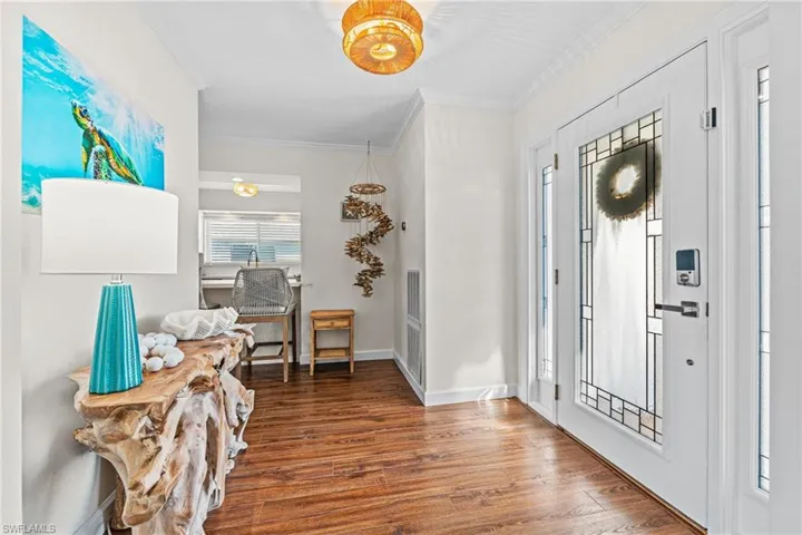 Entrance foyer featuring wood finished floors and ornamental molding
