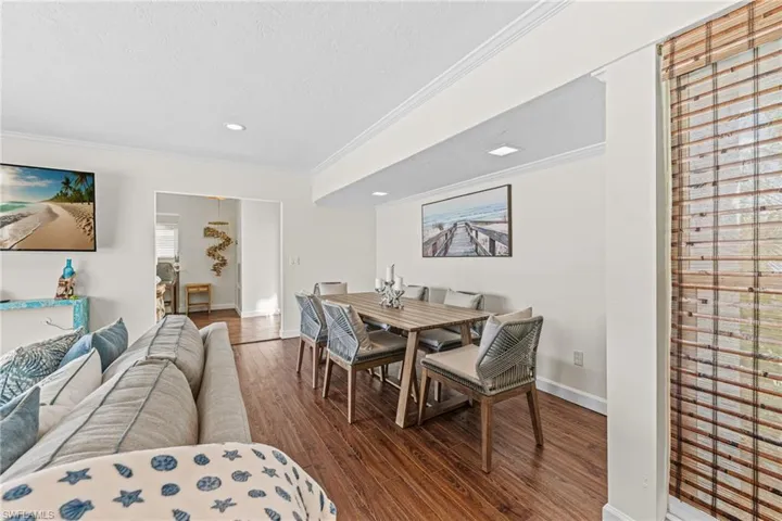 Dining space with ornamental molding, wood finished floors, recessed lighting, and a textured ceiling