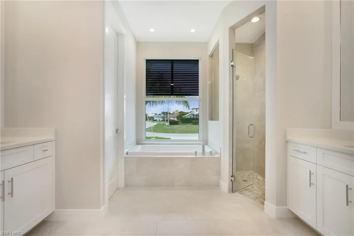 Bathroom featuring plus walk in shower, vanity, and tile patterned floors