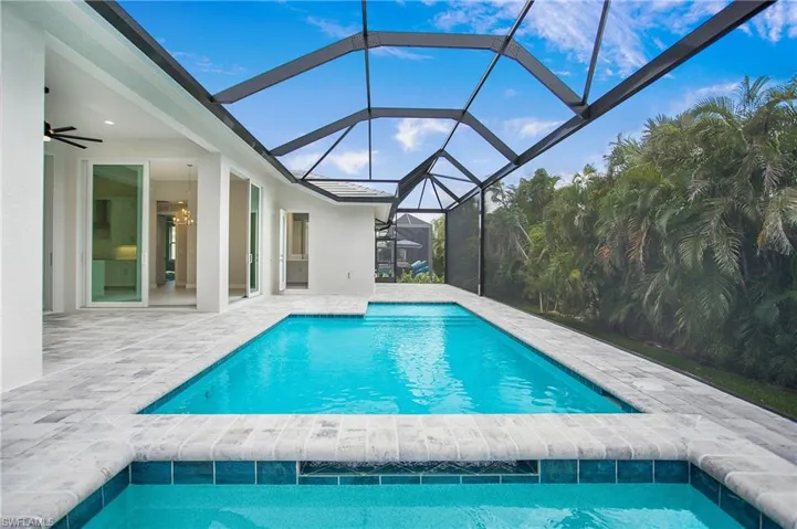 View of pool featuring a lanai, ceiling fan, and a patio