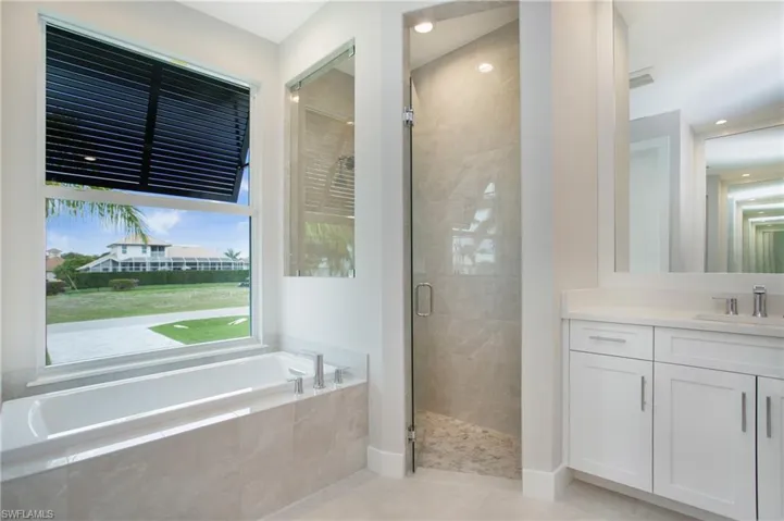 Bathroom with vanity, shower with separate bathtub, and tile patterned floors