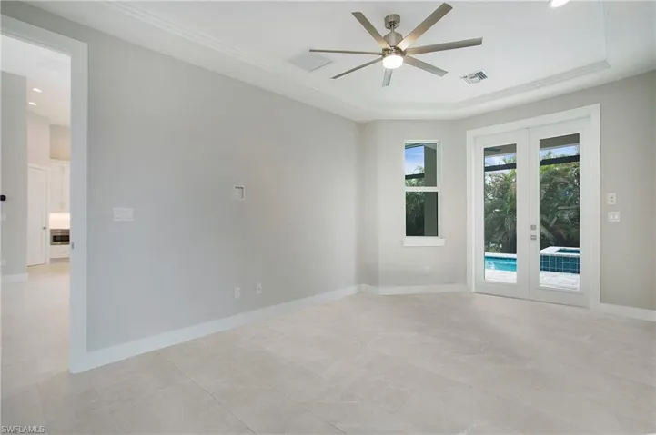 Empty room with french doors, ceiling fan, and crown molding