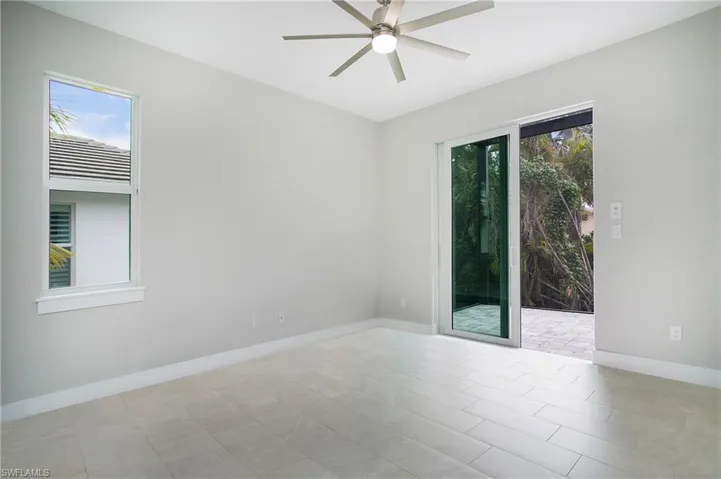Tiled empty room with ceiling fan and a healthy amount of sunlight