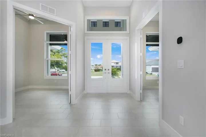 Tiled foyer featuring french doors and ceiling fan