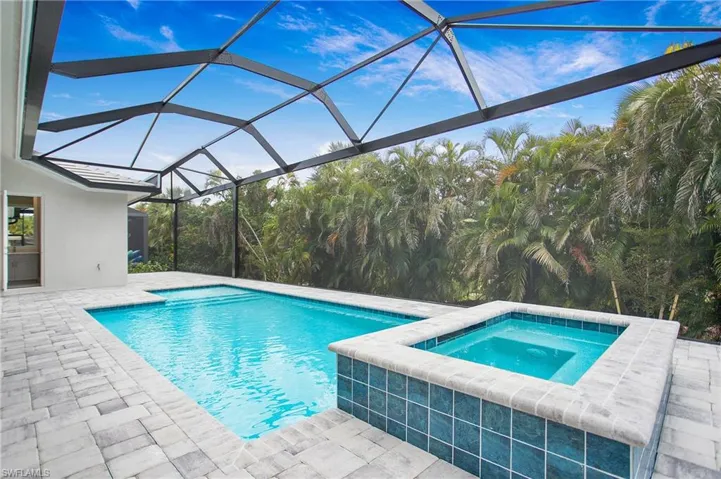 View of swimming pool with a patio, a lanai, and an in ground hot tub