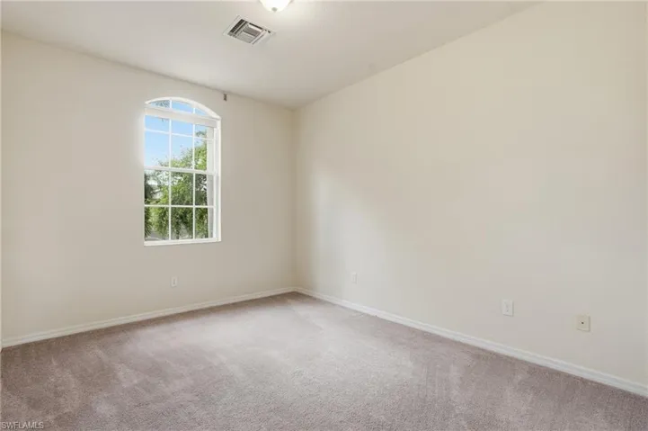 Spare room featuring light colored carpet and baseboards