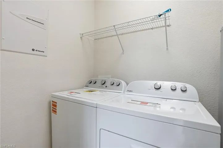 Laundry area with a textured wall and washing machine and dryer