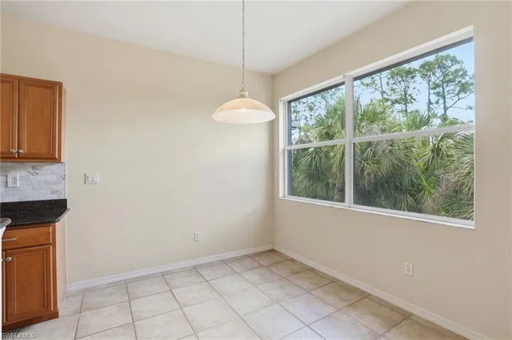 Unfurnished dining area featuring baseboards and light tile patterned flooring
