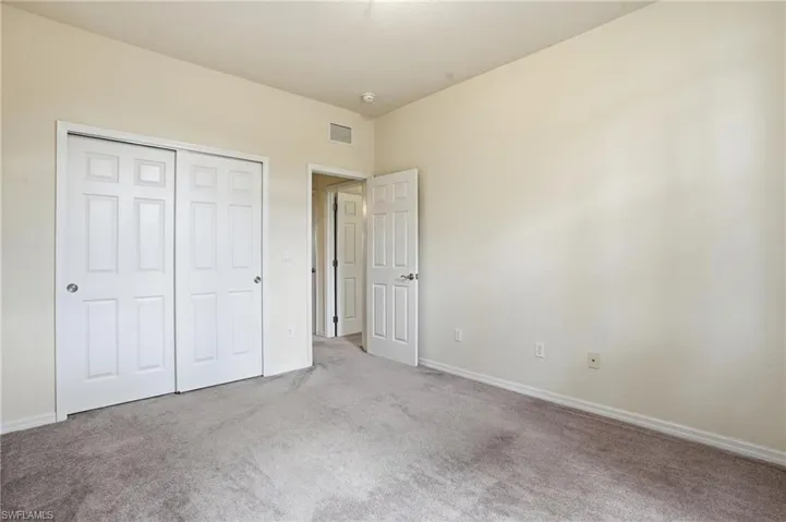Unfurnished bedroom featuring carpet flooring and a closet