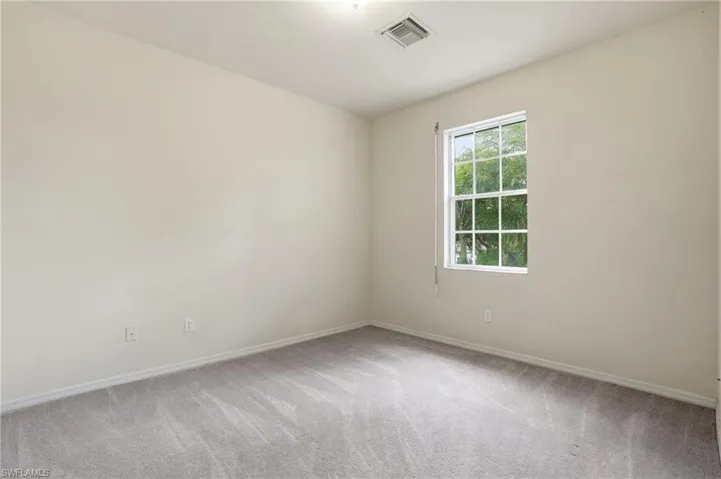 Empty room featuring baseboards and light colored carpet