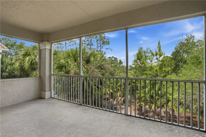 Unfurnished sunroom with a textured ceiling, a textured wall, and carpet