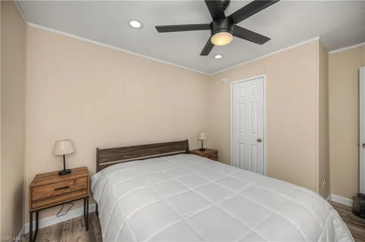 Bedroom with recessed lighting, ornamental molding, dark wood-style flooring, and ceiling fan