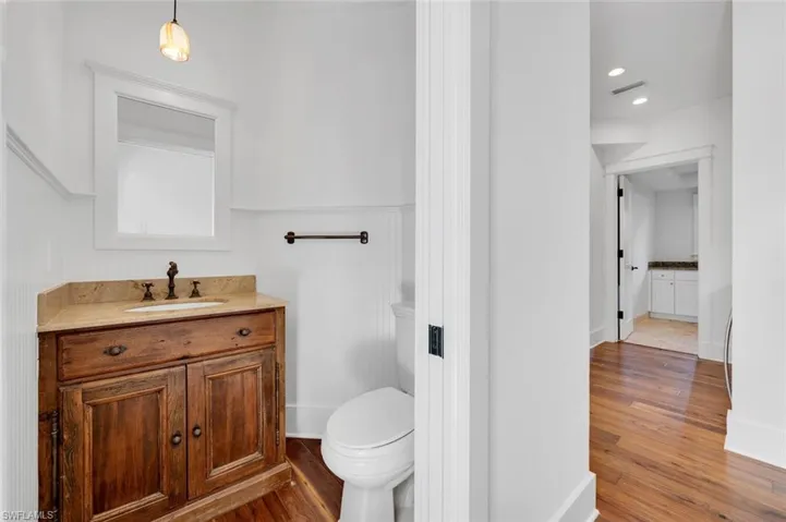 Bathroom featuring wood-type flooring, toilet, and vanity