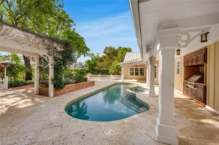 View of swimming pool with exterior kitchen, a patio area, an in ground hot tub, and area for grilling